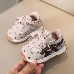 Gros plan détaillé de baskets roses pour tout-petits à pois mignons, bordure en dentelle.