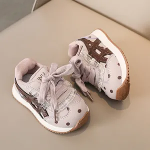 Vue détaillée de baskets décontractées pour tout-petits à pois, bandes et volant en dentelle.