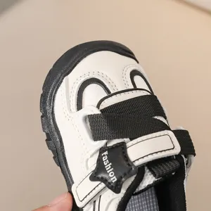 Detailweergave peuter stapschoenen, zwart-wit kleurontwerp, comfortabele ademende stijl.