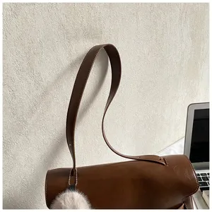 Sac à main bandoulière en cuir marron style Kelly vue détaillée avec poignée élégante.