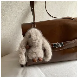 Vue détaillée du sac à épaule en cuir marron élégant avec porte-clés lapin et serrure métallique.