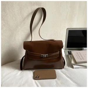Vue détaillée de l'élégant sac à bandoulière en cuir marron avec fermeture élégante et poignée.