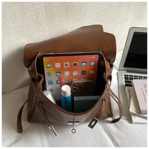 Sac à main élégant en cuir marron avec fermeture à verrou et grand espace de rangement.