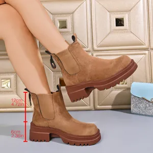 Detailed shot of brown suede platform chelsea boots showcasing chunky heel and texture.