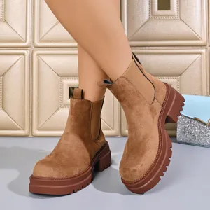 Detail view of women brown suede chelsea boots with thick platform heels, autumn fashion shoes.