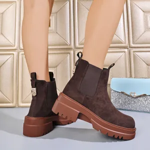 Detail view of brown suede Chelsea boots featuring a chunky platform sole and elastic side panels.