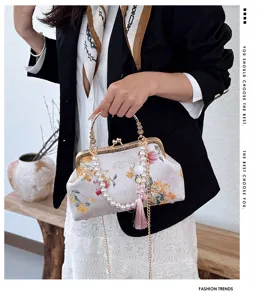 Primo piano della borsa a conchiglia ricamata vintage con perle, struttura e nappa.