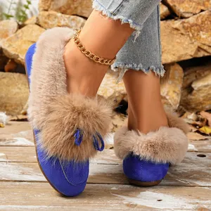 Close-up view of women winter warm plush flat shoes with furry trim and cute bow detail.