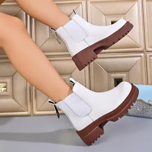 Close-up detail of women white platform chelsea boots with chunky brown lug sole for autumn.
