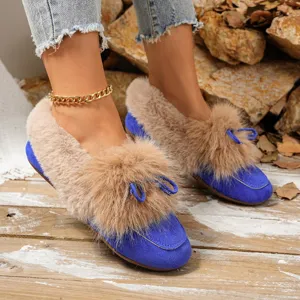 Close-up detail of winter plush fuzzy flats with cute pom-pom bow and warm fleece lining.