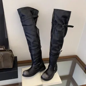 Black over-the-knee boots with retro buckle, slouchy design, and distressed round toe.