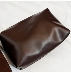 Brown faux leather pouch bag detail view, minimalist design, soft texture, daily accessory.