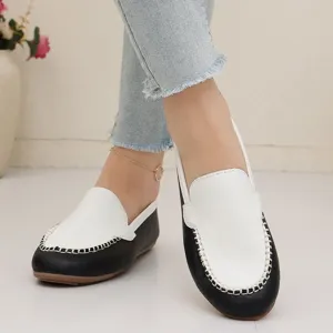 Detailaufnahme von Damen schwarz-weißen flachen Slip-On Freizeitschuhen mit feinen Nähten.