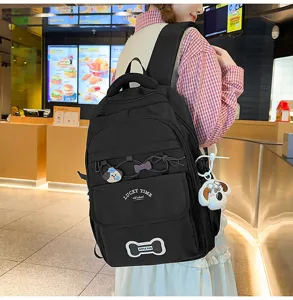 Nahaufnahme des schwarzen Studentenrucksacks mit mehrschichtigem Stauraum und niedlichen Welpen.