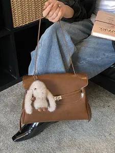 Sac à bandoulière marron en cuir pour femme, élégant sac Kelly avec verrou métallique.