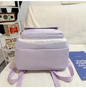 Detailansicht des lila-weißen Farbdruck-Rucksacks mit mehrschichtigen Vordertaschen und Trägern.