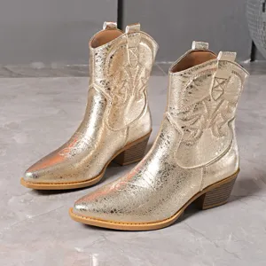 Détail de bottes de cowboy dorées métalliques, bout pointu et talon bloc, broderie.
