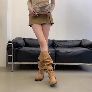 Detail shot of retro slouchy boots with multiple buckle straps and chunky heels for women winter.