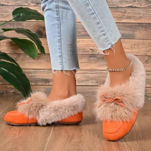 Close up detail of women plush furry flat shoes with orange suede and soft warm fur.