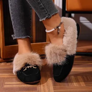 Gros-plan de chaussures plates d'hiver noires pour femmes avec bordure en peluche et mors en métal.