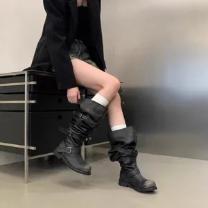 Detail view of vintage black buckle slouchy boots featuring chunky heels and distressed toe design.
