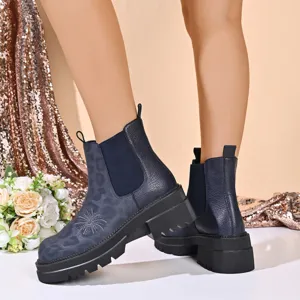 Detail view of dark blue platform chelsea boots with leopard texture and lug sole for women.