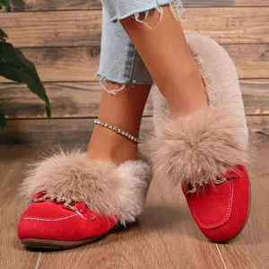 Détail de chaussures plates en peluche rouge chaude avec col en fausse fourrure et daim.