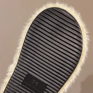 Primo piano sulla suola delle morbide pantofole peluche con scanalature antiscivolo.