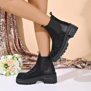 Close-up detail shot of stylish women's black platform chelsea boots with leopard print.