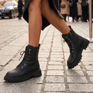 Nahaufnahme schwarzer Damen Boots aus Leder mit Plateau, Schnürung und Reißverschluss.