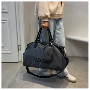 Detailed shot of large capacity grey travel duffel bag with shoulder strap for gym and trips.