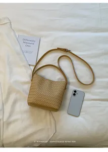 Detail shot of the beige woven leather bucket bag featuring soft texture and chic shoulder strap.