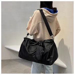 Large capacity black travel duffel bag with shoulder strap and small pouch for gym.