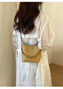 Woven leather bucket bag detail, soft camel leather crossbody strap and retro minimalist vibe.