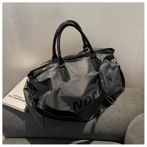 Close-up view of the dark grey travel duffel bag showing texture, straps, and compact pouch.