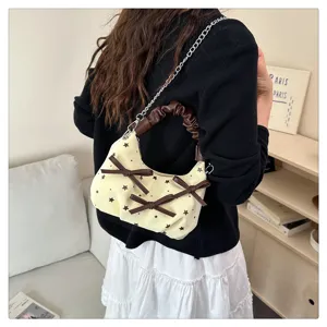 Detail view of a chic Korean style shoulder bag with bows, star print and chain strap.