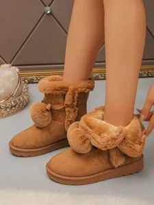 Brown suede snow boots detail with fluffy faux fur, sweet pom-poms, and cozy winter warmth.
