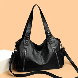 Detail shot of black leather tote bag with metal zippers and comfortable shoulder straps.
