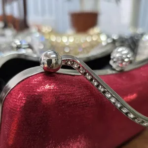 Red rhinestone evening clutch bag featuring sparkling metal clasp and fine details