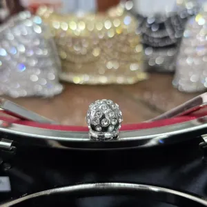 Rhinestone evening bag metal clasp detail close-up, sparkly crystal ball lock for luxury purse.
