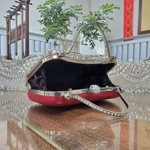 Detail view of a stunning red rhinestone evening clutch bag with metallic handle and clasp.