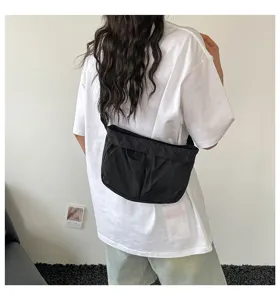 Casual zwarte nylon schoudertas in effen kleur, eenvoudig geplooid ontwerp voor dagelijks gebruik.