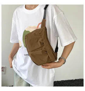 Gedetailleerd overzicht van bruine nylon crossbodytas gedragen door model, eenvoudige stijl.