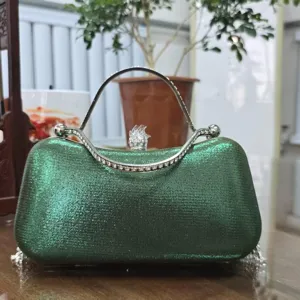 Green glitter evening clutch bag detail showing rhinestone handle and lock closure.