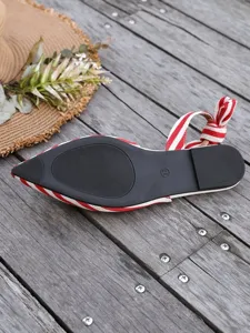 Red and white striped pointed toe flat sandals with bow detail showing the shoe outsole.