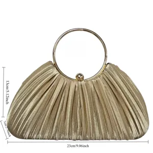 Detailed view of gold pleated evening clutch bag with elegant round metal ring handle.