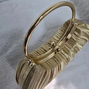 Gold pleated evening clutch bag featuring a sleek metal round handle and secure clasp closure.