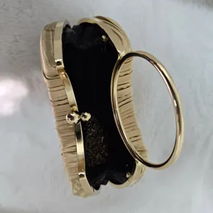 Gold pleated evening clutch bag interior detail, featuring metal round handle and chain strap.