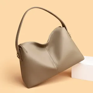 Detail view of the stylish taupe leather shoulder bag showing smooth zipper and premium texture.