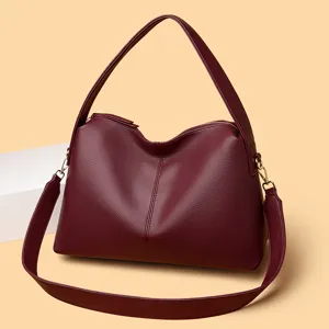 Wine red leather hobo shoulder bag detail, textured fabric and shiny golden hardware.